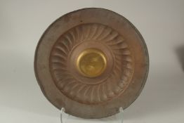 AN ANTIQUE BRASS ALMS DISH, 40.5cm diameter.