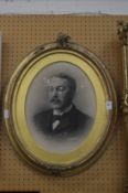 Photographic print of an Edwardian gentleman in a gilt oval frame.