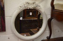 A small circular mirror with decorative painted frame.