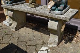 A reconstituted stone rectangular garden bench with curving supports.