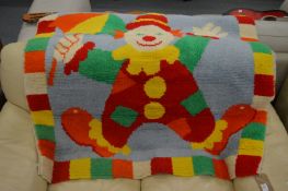 A nursery rug decorated with a clown 115cm x 115cm.
