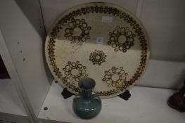 A carved alabaster charger and a pottery vase.