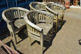 A set of four teak garden armchairs.