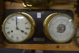 A brass ships clock and matching barometer/thermometer mounted on a hanging board together with a