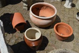 A large terracotta circular planter and three other items.