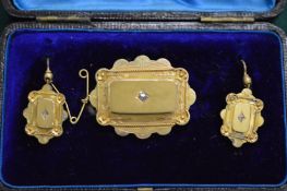 A Victorian yellow metal garniture comprising brooch and pair of earrings, boxed.