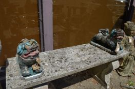 A pair of painted reconstituted stone ornaments modelled as Buddhistic lions.