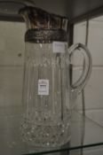 Cut glass lemonade jug with plated mount.