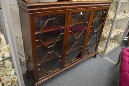 A mahogany four door bookcase on claw and ball feet.
