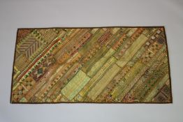 An Indian thread embroidered textile with inset mirror roundels 148cm x 77cm.