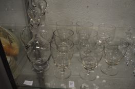 A pair of glass claret jugs and eight large wine glasses.