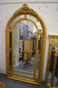 A large gilt framed arch topped mirror 225cm high x 115cm wide.
