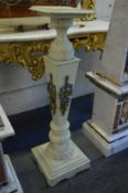A painted carved wood pedestal.