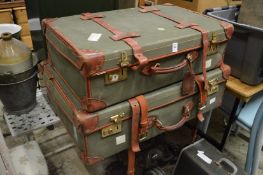 Two leather bound and canvas suitcases.
