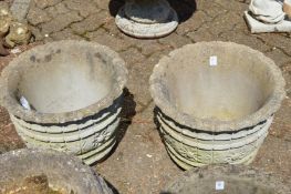 A pair of reconstituted stone garden planters.