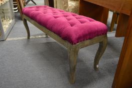A decoratively upholstered long foot stool.