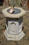 A small reconstituted stone hexagonal shaped sun dial.