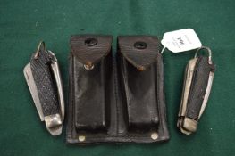 Leather pouch containing two army knives.