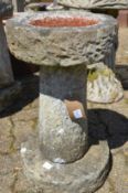 A reconstituted stone bird bath.