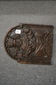 A carved oak plaque depicting a King seated on a throne holding the orb and sceptre.