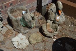 A reconstituted stone garden planter modelled as a swan together with other decorative items.