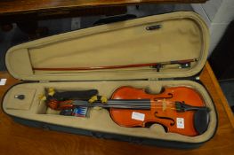 A student violin and bow with case and accessories.