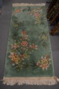 A green ground Chinese rug 165cm x 78cm.