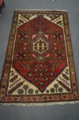 A modern Persian style rug, red ground with stylised decoration 155cm x 100cm.