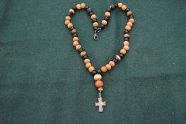 A worry bead necklace with small bronze cross.