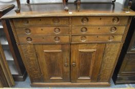 A mahogany sideboard with arrangement of six drawers over pair of panelled doors, all with turned