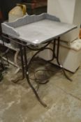 A wrought iron and marble top wash stand.