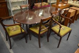 A Georgian style mahogany twin pillar dining table with an extra leaf together with a set of six