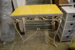 A wrought iron and tile topped table.