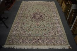 A Persian design machine made carpet, pale green ground with floral decoration 230cm x 160cm.