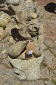 A reconstituted stone garden ornament modelled as a gargoyle.