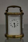 A small oval cased brass carriage clock.