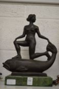 An unusual bronze of a female nude standing on a fish.