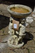 A small reconstituted stone figural bird bath.