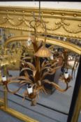 A decorative five branch chandelier with pair of matching two branch wall lights.