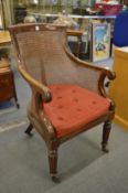 An early 19th century mahogany bergere armchair.
