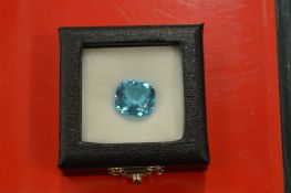A large cushion cut blue topaz with certificate.
