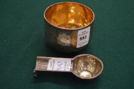 A silver tumbler cup and silver pipe rest.