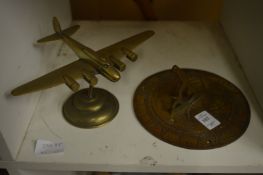 A brass sun dial and a brass model of an aeroplane.