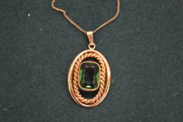 A decorative rolled gold pendant and chain.