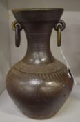 A pottery vessel with ring handles.