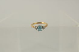 AN 18ct YELLOW GOLD, AQUAMARINE AND DIAMOND THREE STONE RING.