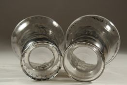 A PAIR OF GLASS VASES WITH COACHING SCENES. 6.5cms high.