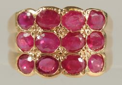 AN UNUSUAL 14ct YELLOW GOLD RING SET WITH TWELVE RUBIES (2.00ct approx.), boxed.
