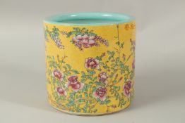 A CHINESE YELLOW GROUND PORCELAIN BRUSH POT painted with flowers. 18cms high.