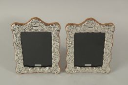 A PAIR OF SILVER EMBOSSED PHOTOGRAPH FRAMES. 20cms x 14cms.